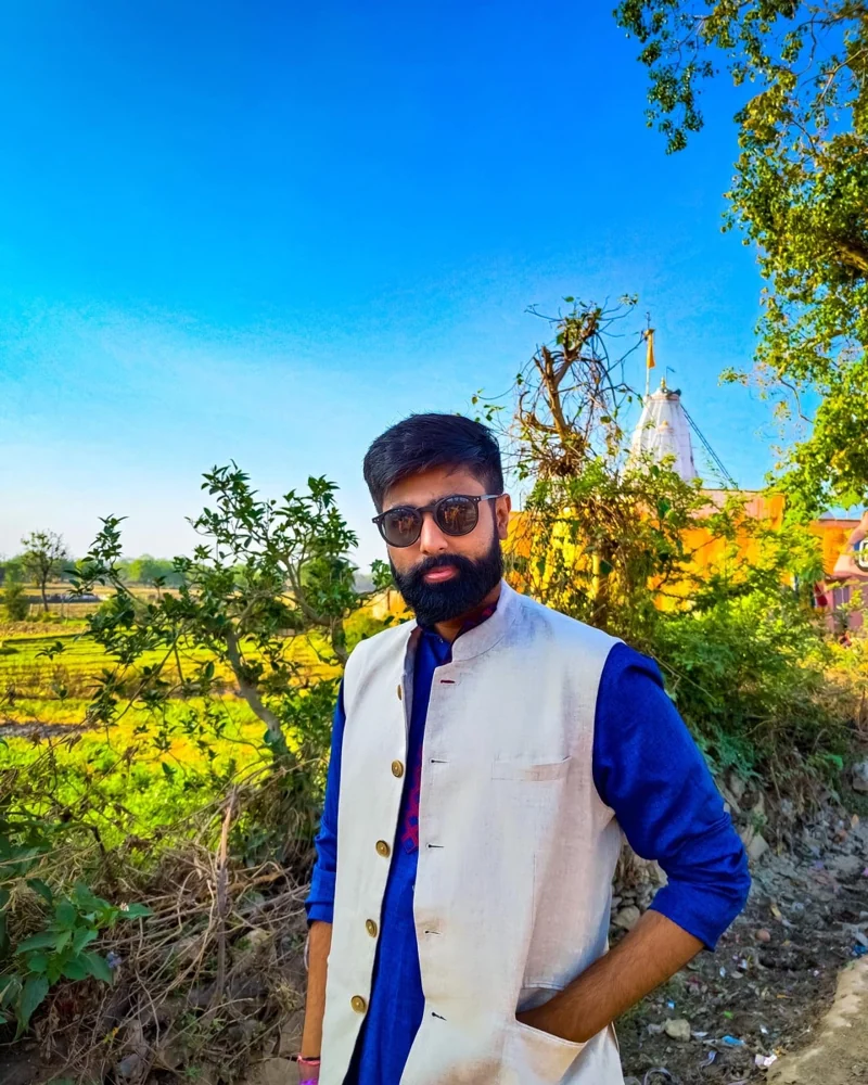 Aditya outdoors, wearing a blue kurta and cream vest